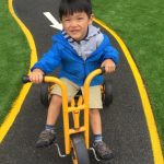 boy on a yellow tricycle