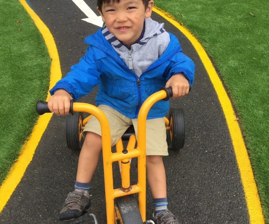 boy on a yellow tricycle